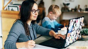 Women working on laptop at table with child