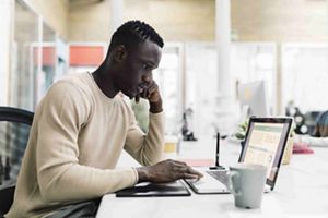 Man sitting at table working on a laptop