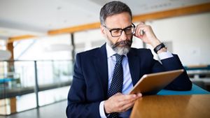 Mature business man using a digital tablet at office