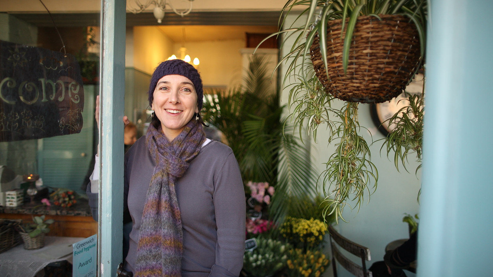 Smiling person standing in shop doorway