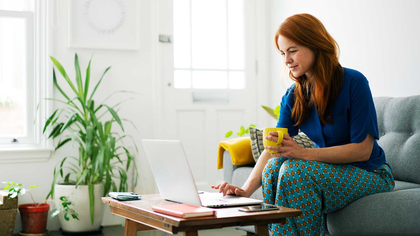 woman-with a mug using-laptop-at-home