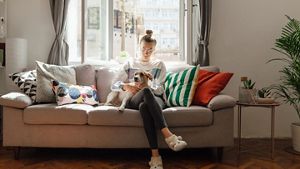Person with dog on lap in living room
