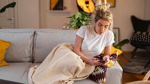 Person on mobile phone on couch