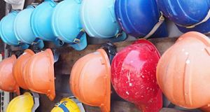 Colourful hard safety hats hung up on a wall