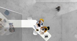 Birds eye view of an office with two people sat at a desk
