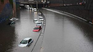 cars drive through flooded road