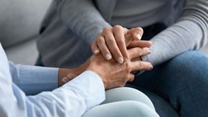 Young woman holding old female hand