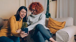 Two middle-aged women having fun on a mobile phone