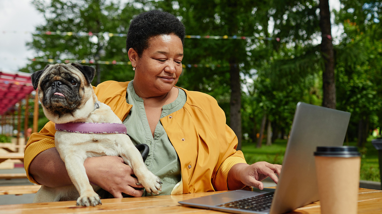 Adult female looking at laptop and holding their dog