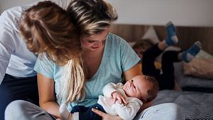 Mother holding baby with father and older child