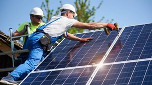 Man installing a solar panel onto a roof
