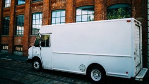 Large white van parked in front of a building