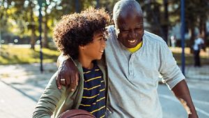 Grandparent with their arm around their grandchild, in an outdoor leisure setting