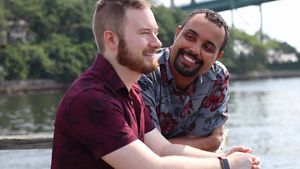 A couple engaging in a light hearted discussion by the water front – in an outdoor setting.
