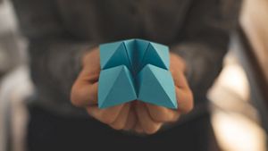 Person performing origami with blue paper