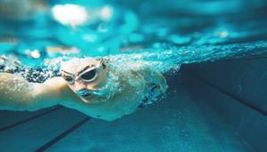 Person swimming underwater in a swimming pool