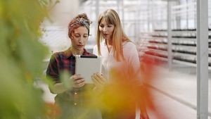 Person showing something on a tablet to someone else