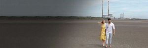 It takes Aviva - couple walking on the beach with Poolbeg towers in the background