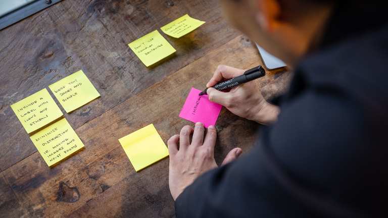 Brian writing accessibility tips on Post-It notes