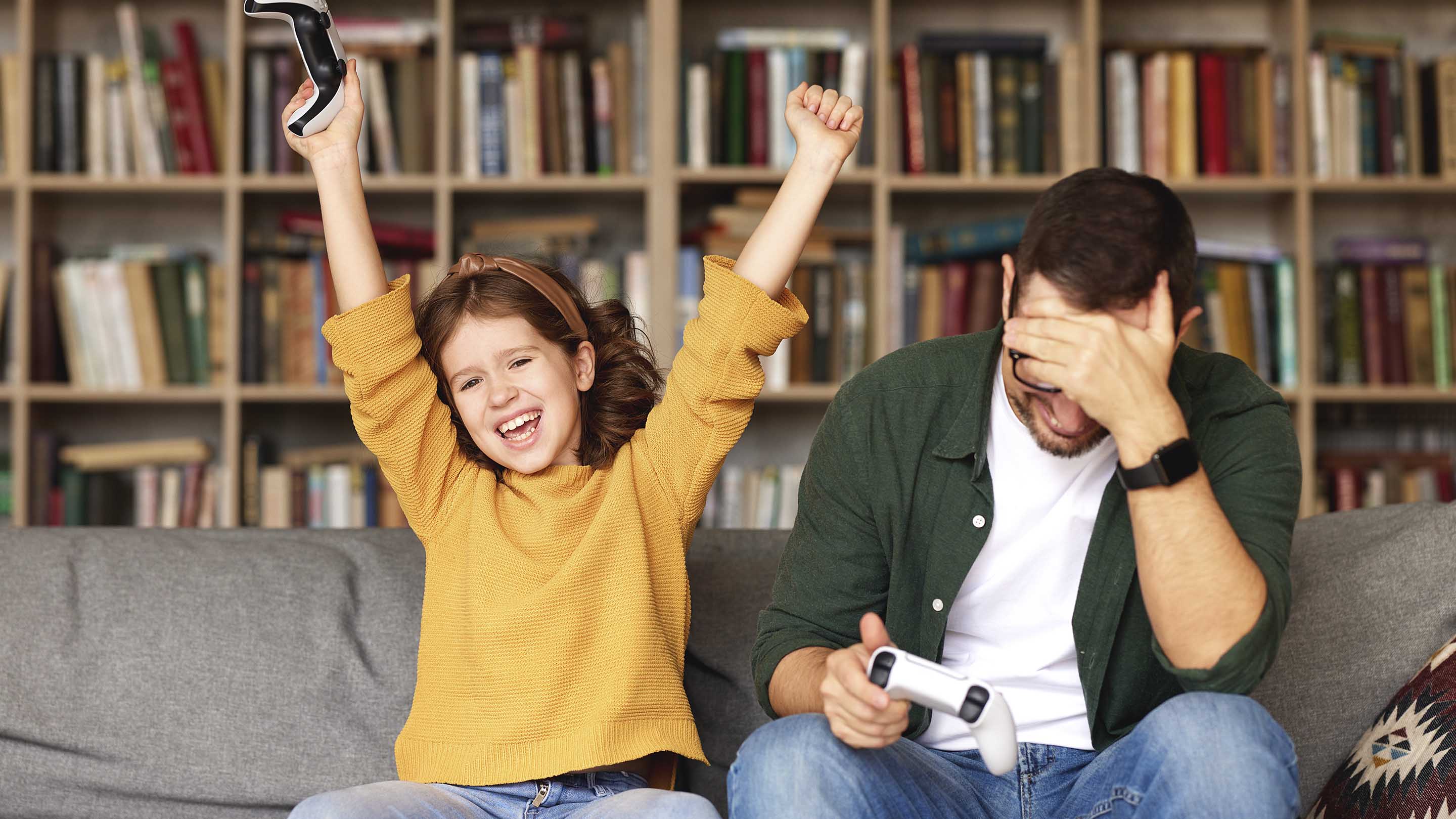 Father and daughter playing on a games console