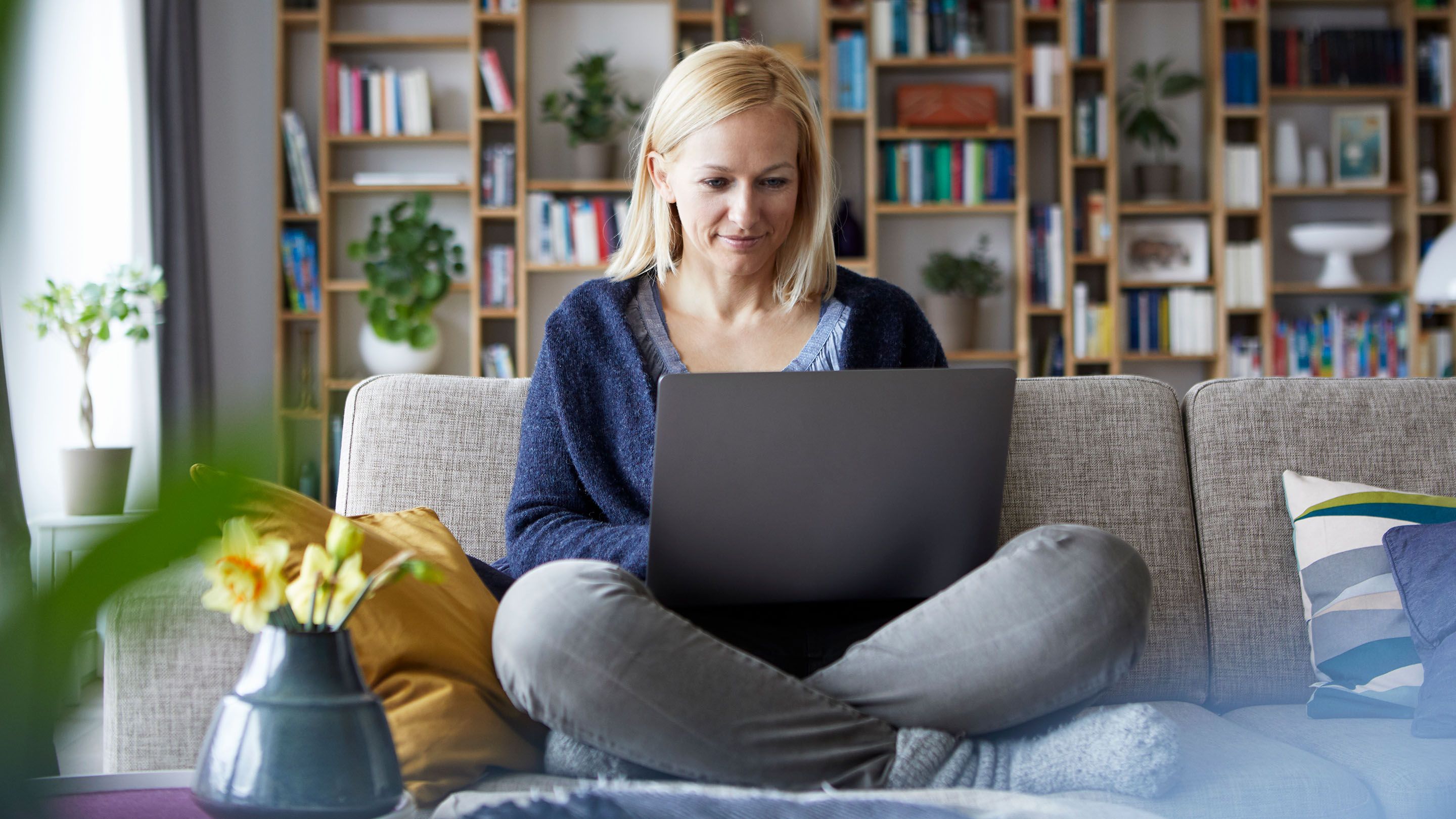 Person using a laptop on their living room sofa