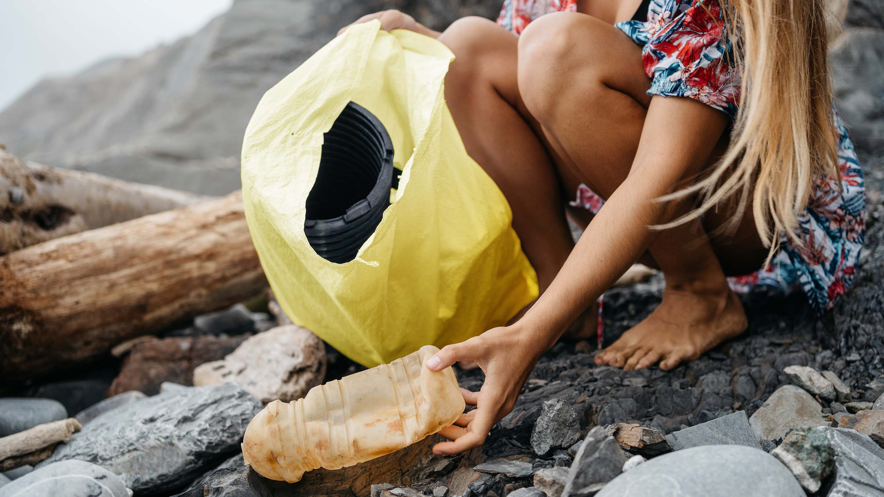 Woman collecting litter on beach