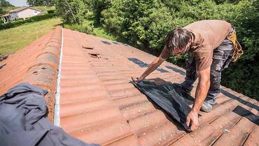 Picture of a man fixing a roof
