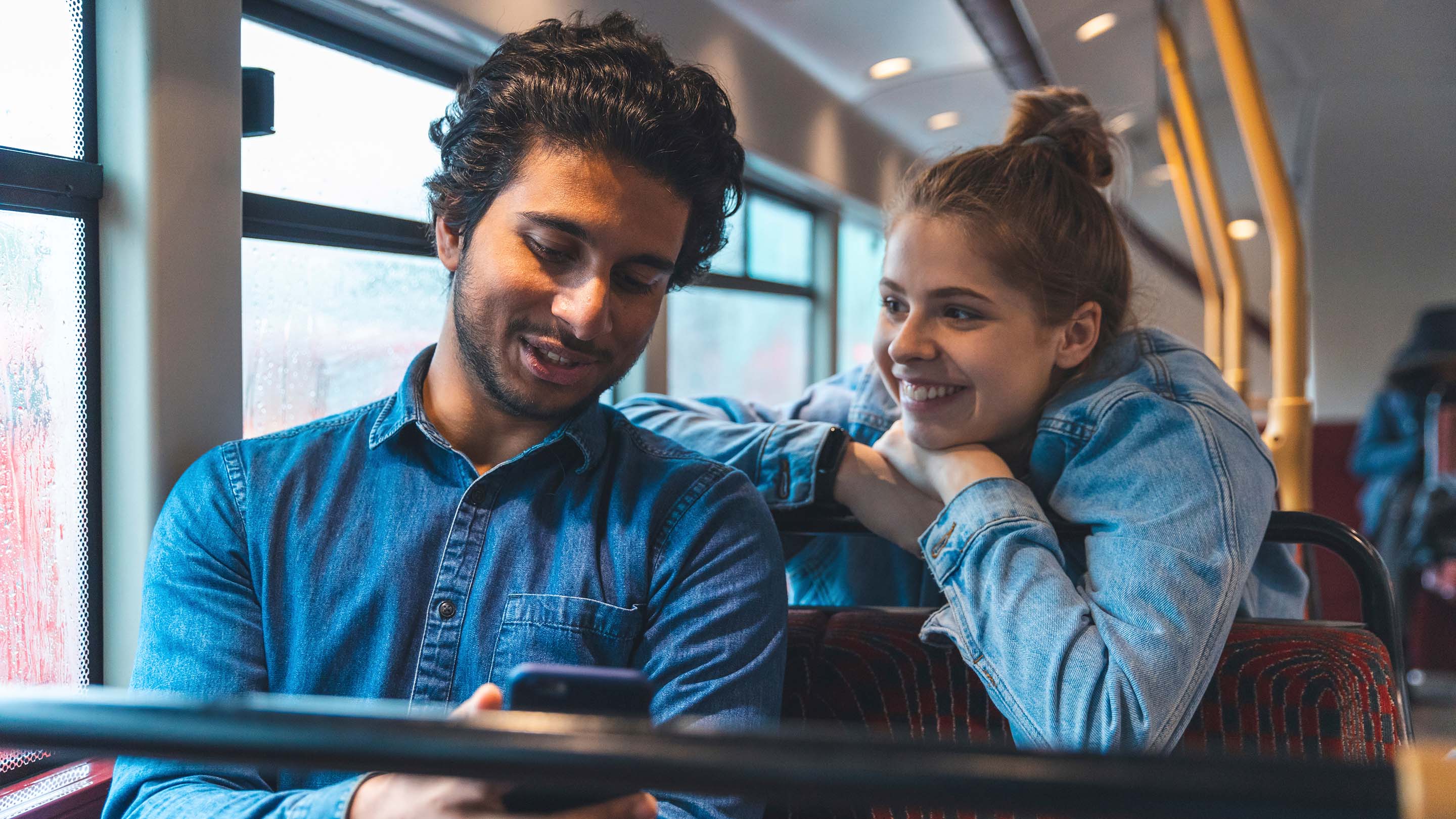 Young couple travelling by bus on a rainy day