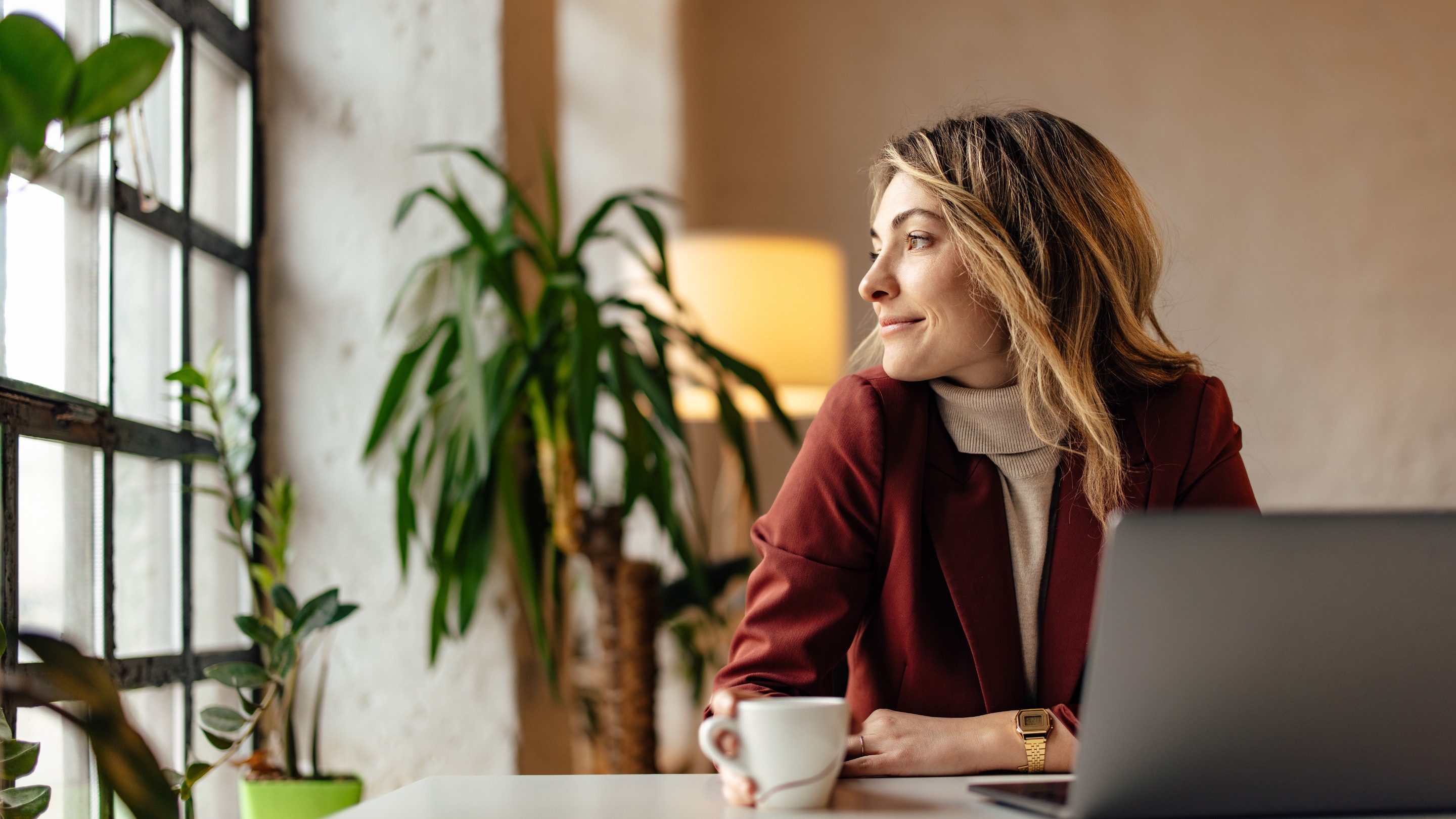 business woman smiling and looking out of a window