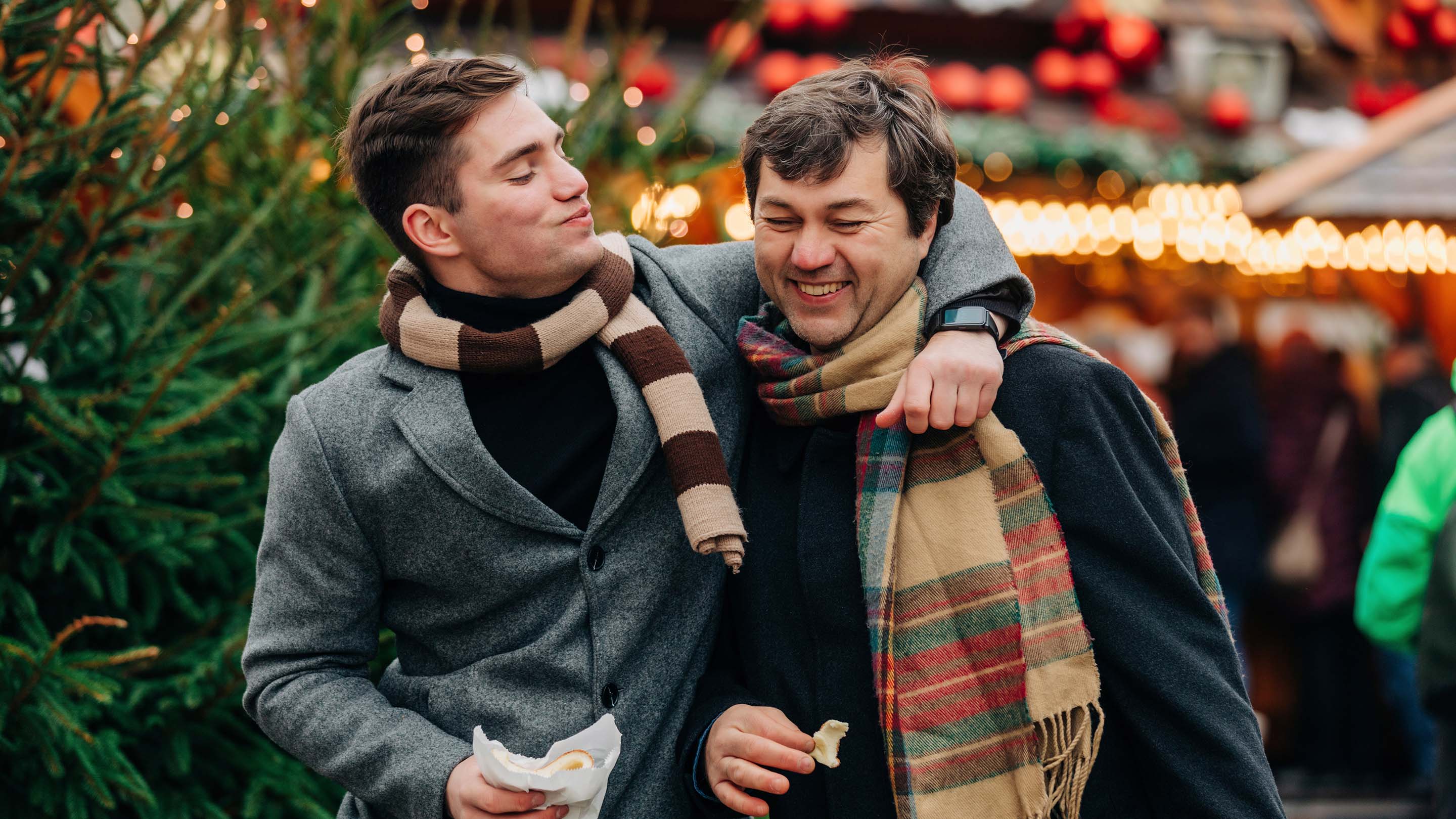 Two men smiling at a Christmas market