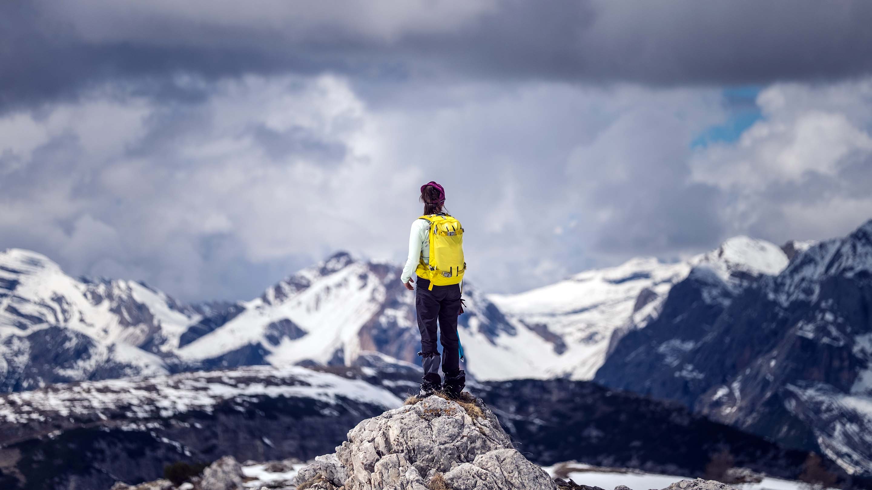 Tourist standing on a stone in the snowy mountains