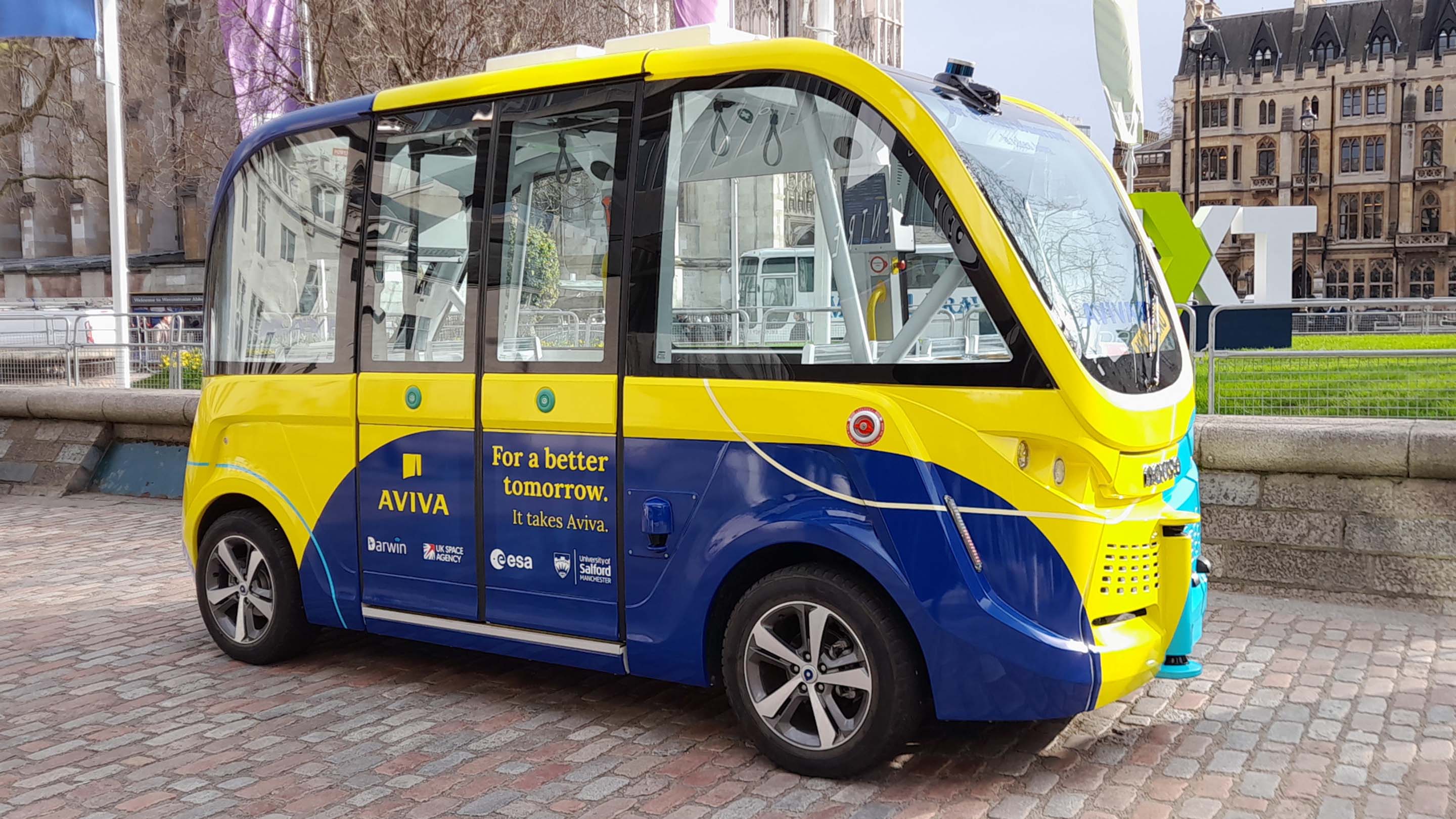 The autonomous shuttle, wrapped in yellow and blue Aviva branding