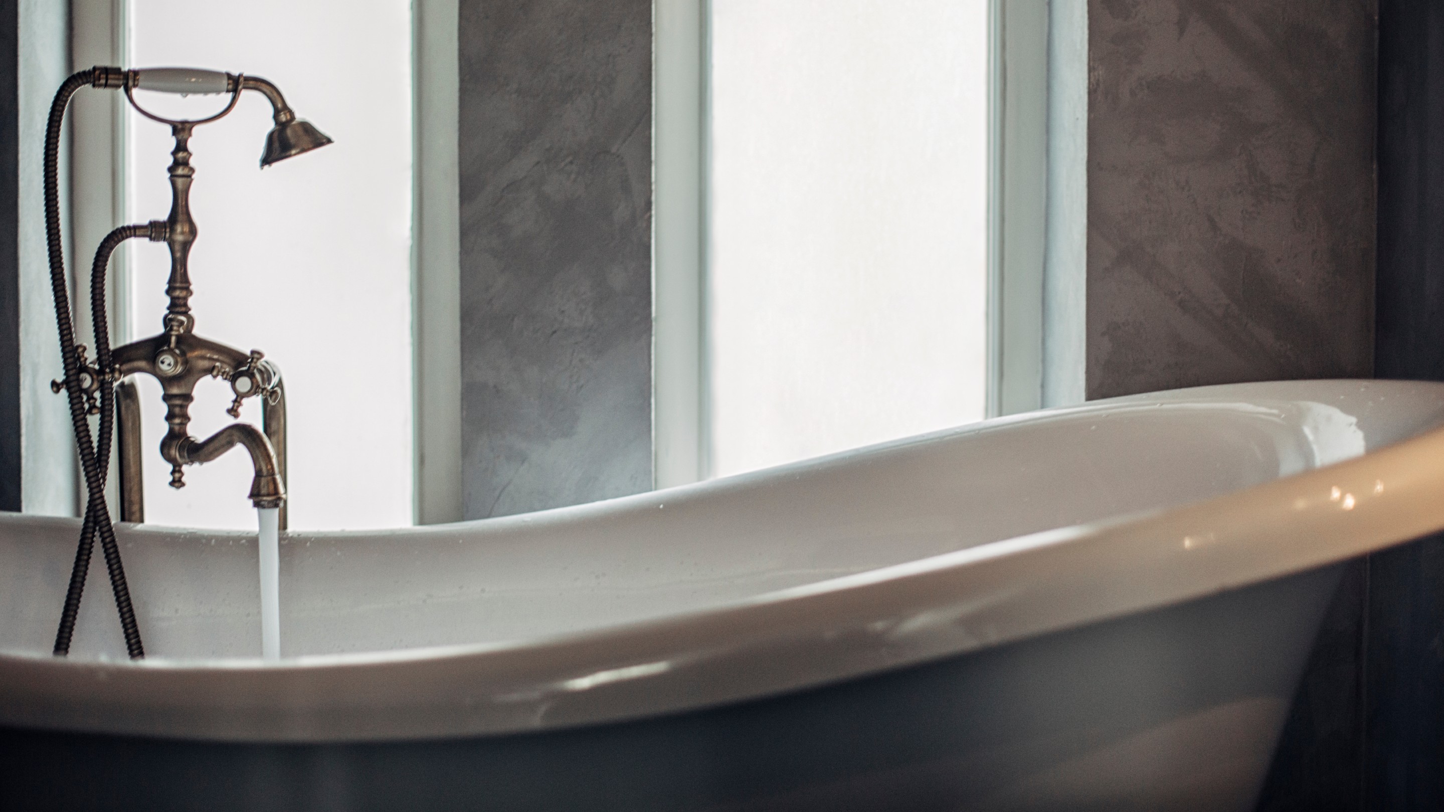 White bathtub being filled with bath water
