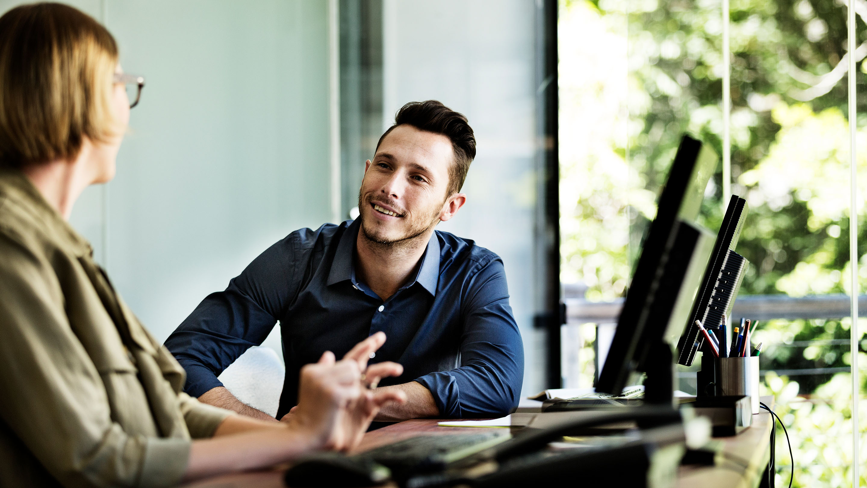 Business people talking at a computer desk