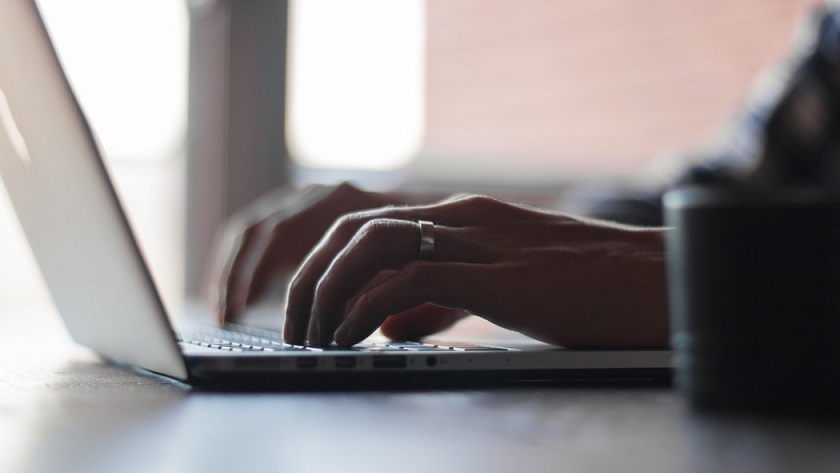 Close up of hands typing on a laptop.