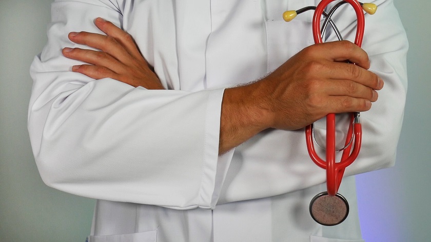 Close up of a doctor in a white coat holding a stethoscope