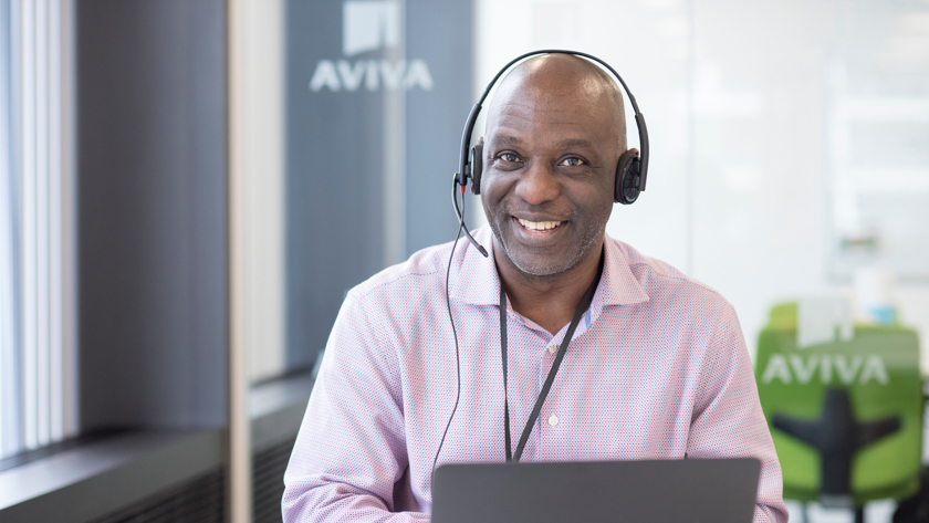 Man wearing telephone headset with Aviva logo in the background