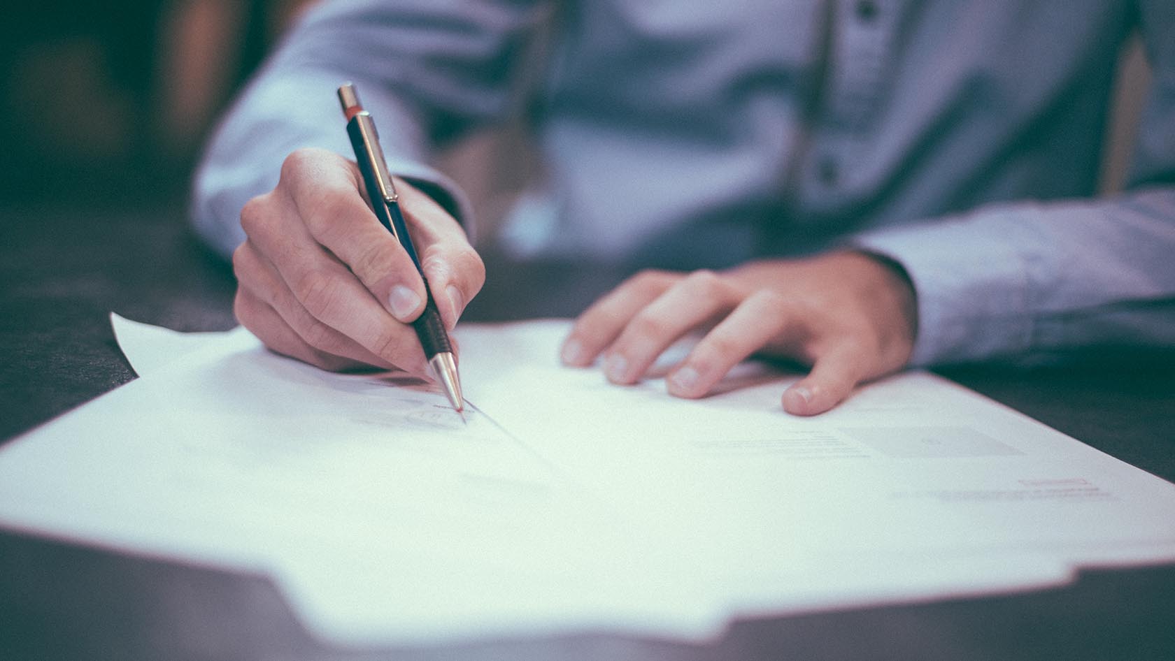 A man signing some paper documents