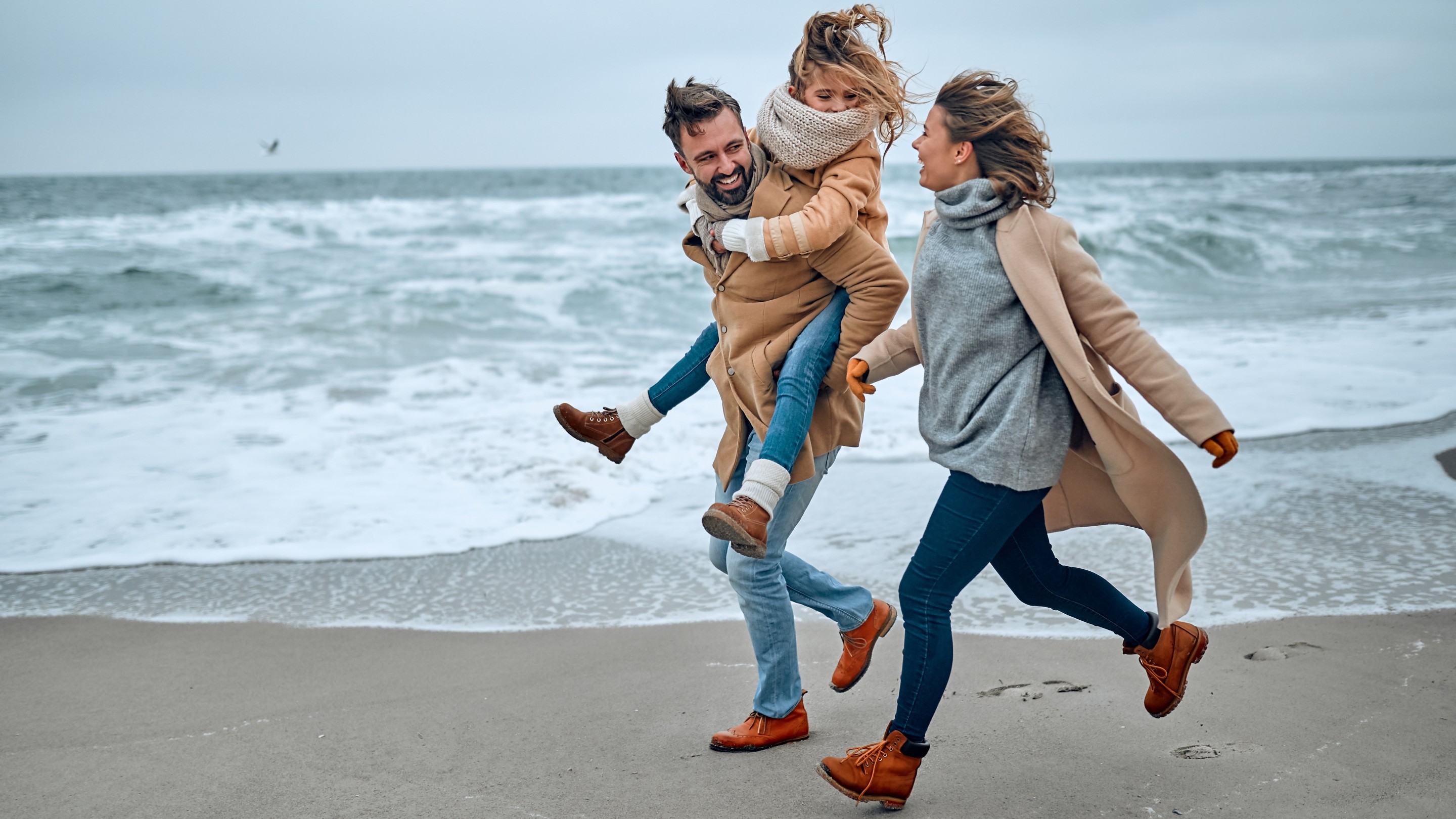 family running on a beach