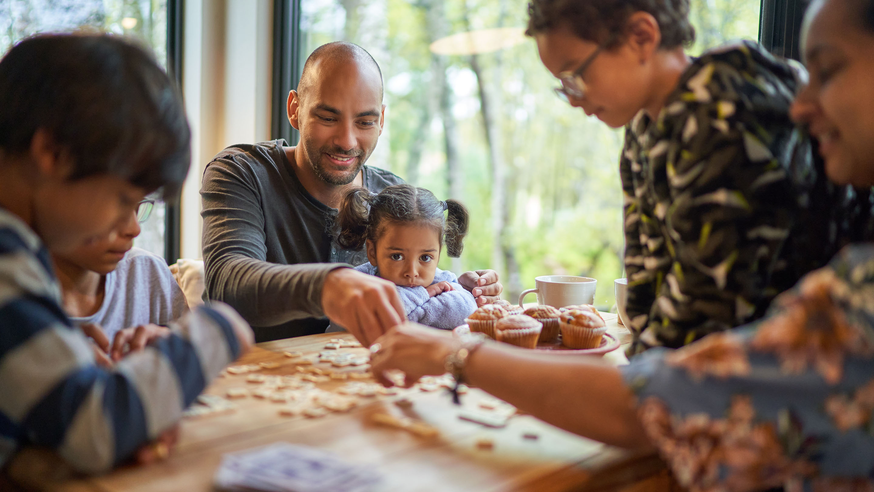 Family playing scrabble at dining table