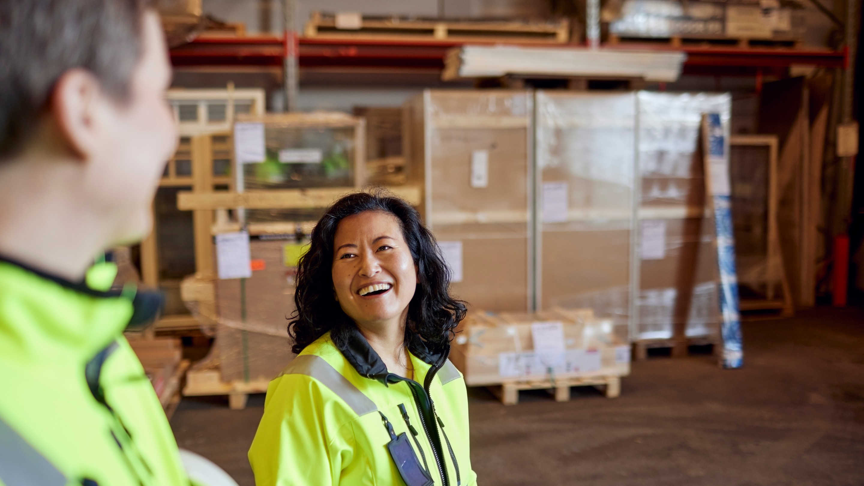 Female warehouse worker smiling at male warehouse worker