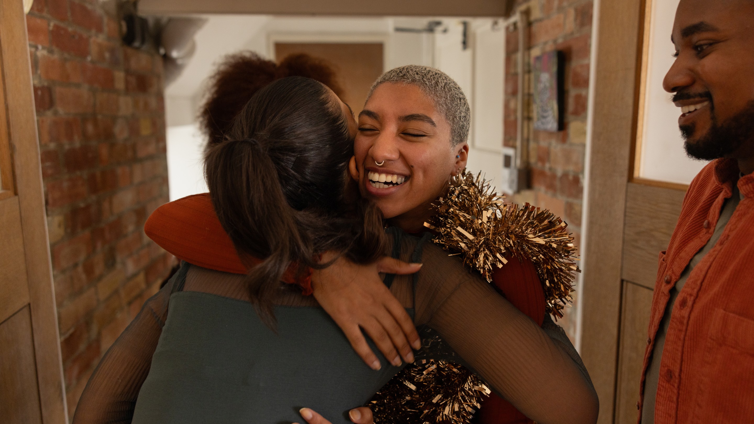 Friend arriving at a Christmas party giving a big hug to the host