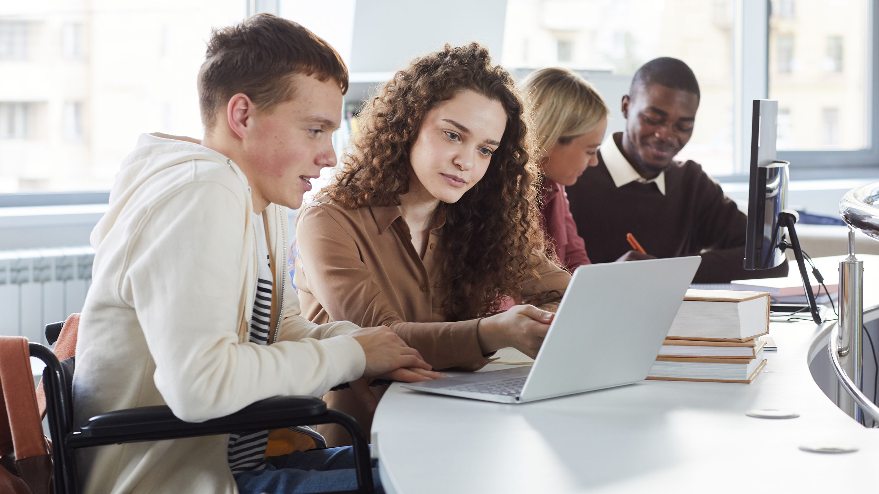 Group of students using laptops whilst studying