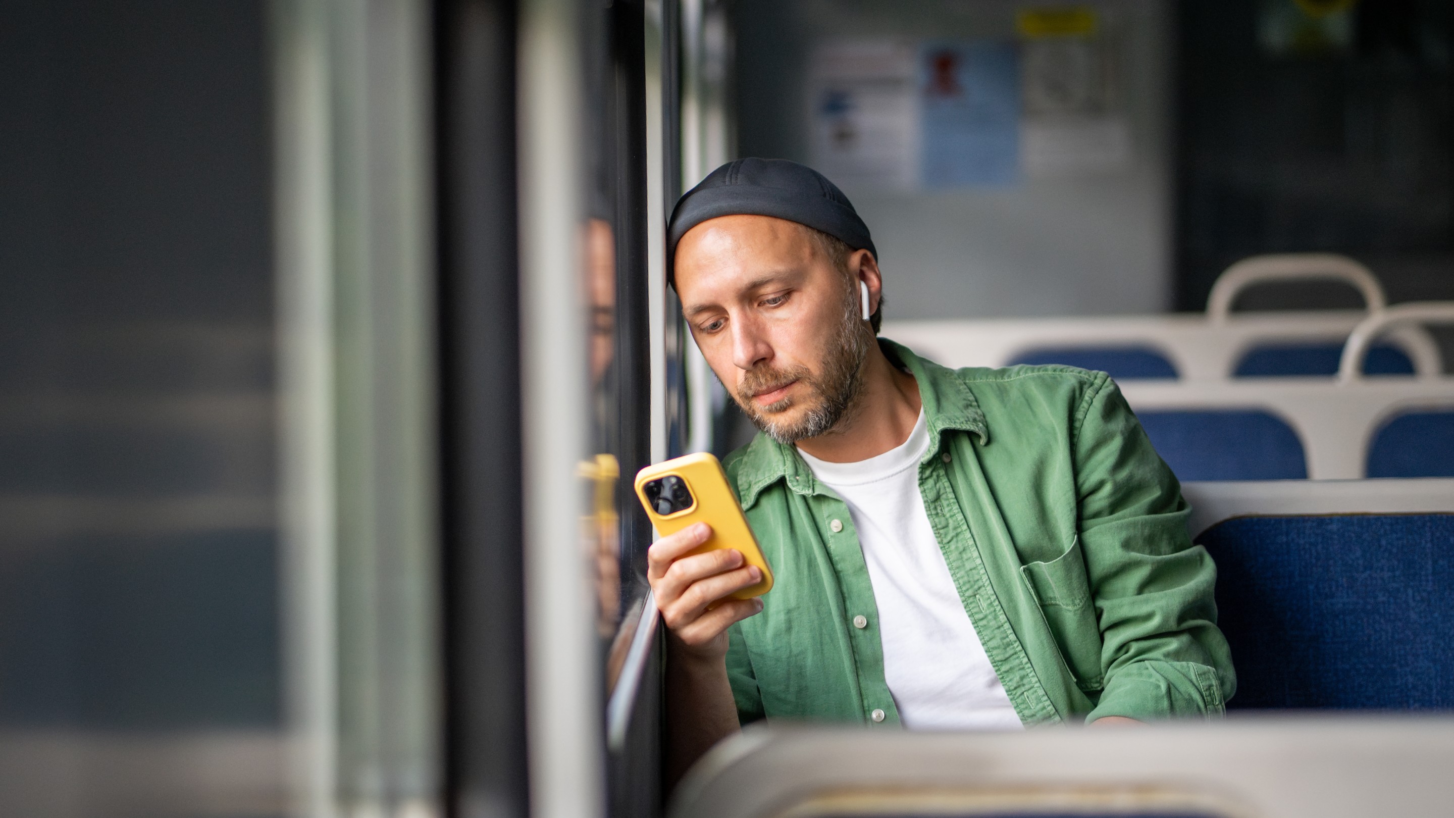 Man on bus looking at phone