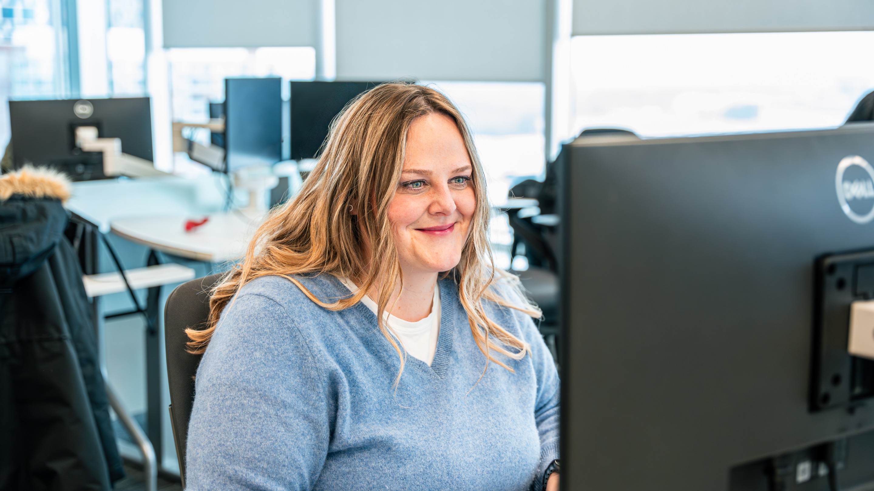 Melissa working at a computer in our Canada office