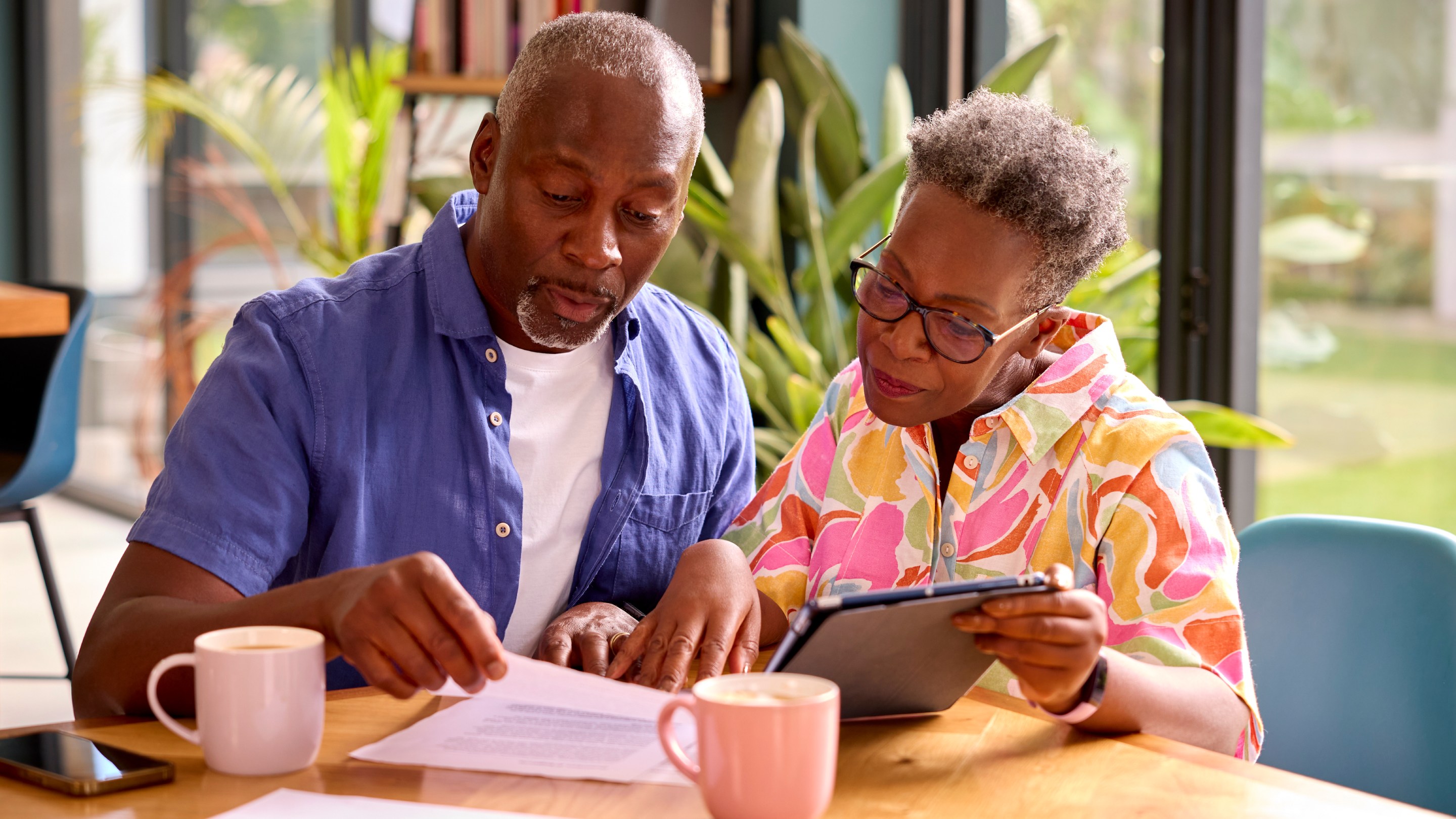 Senior couple sitting at desk reading documents
