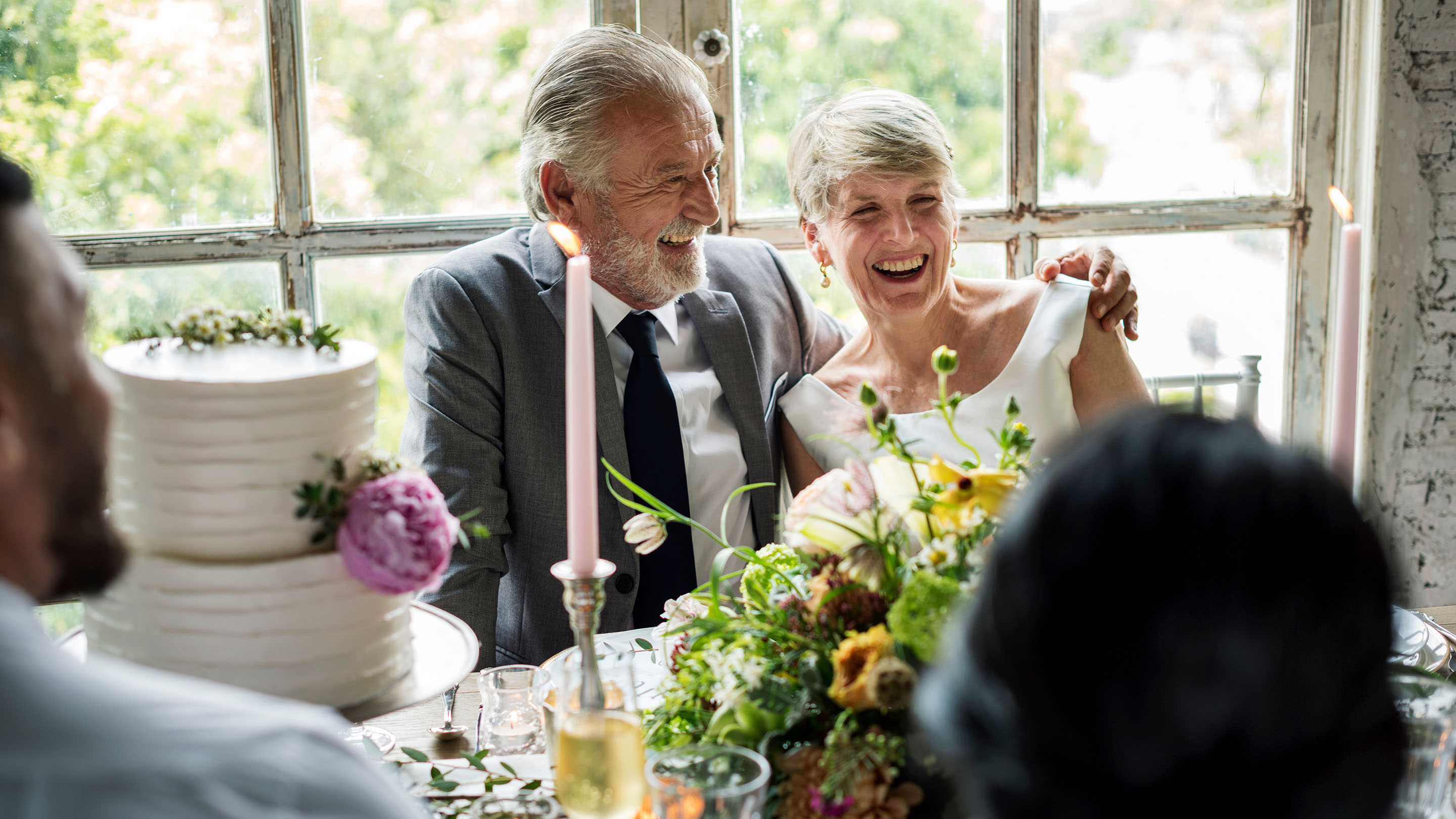Senior couple sitting together cheerful at a wedding