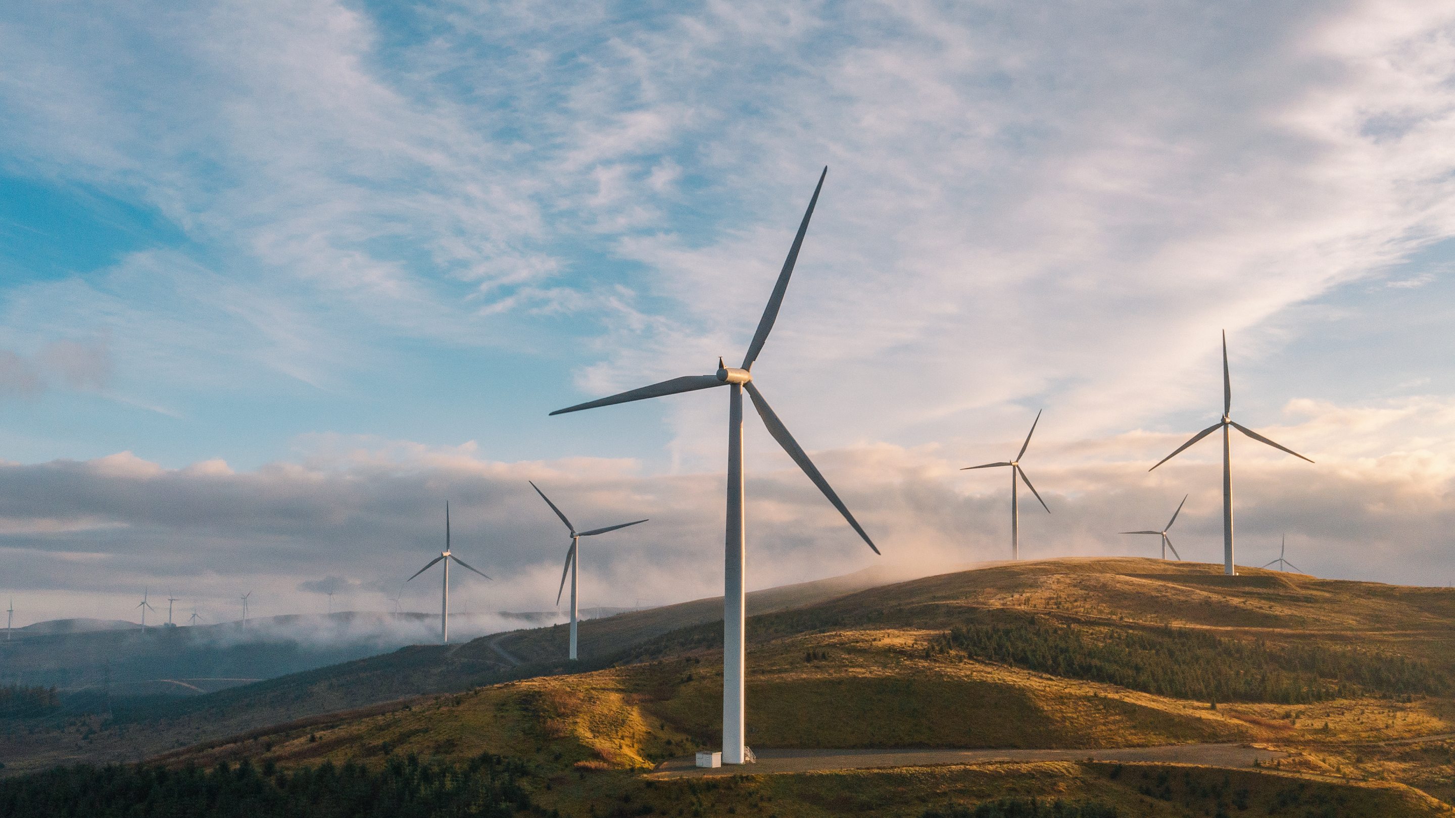 Sunset drone view of a wind farm on a hilltop 