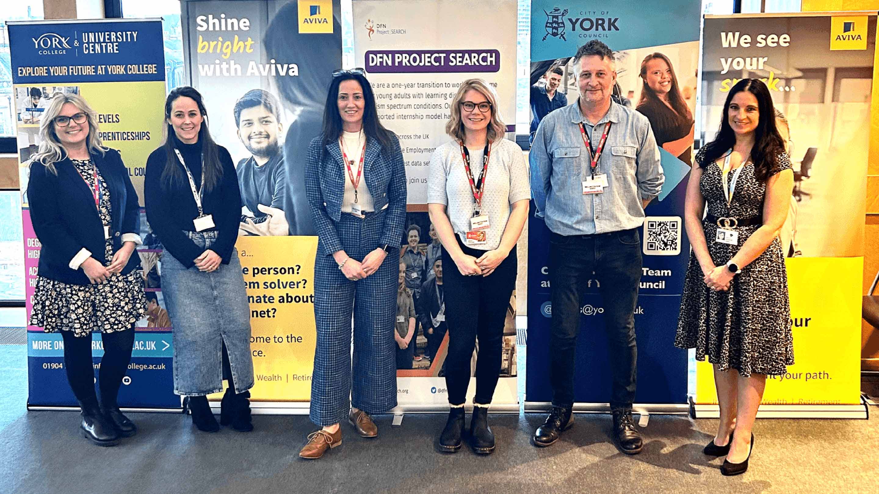 People standing in front of pull-up banners for Aviva, City of York Council, York College and other partners