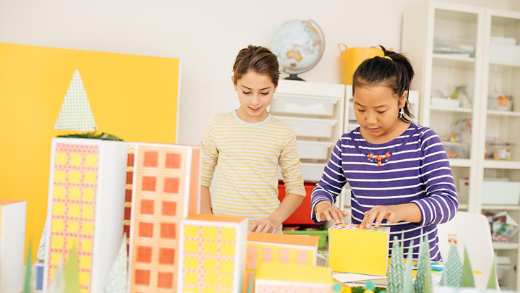 two girls building model buildings